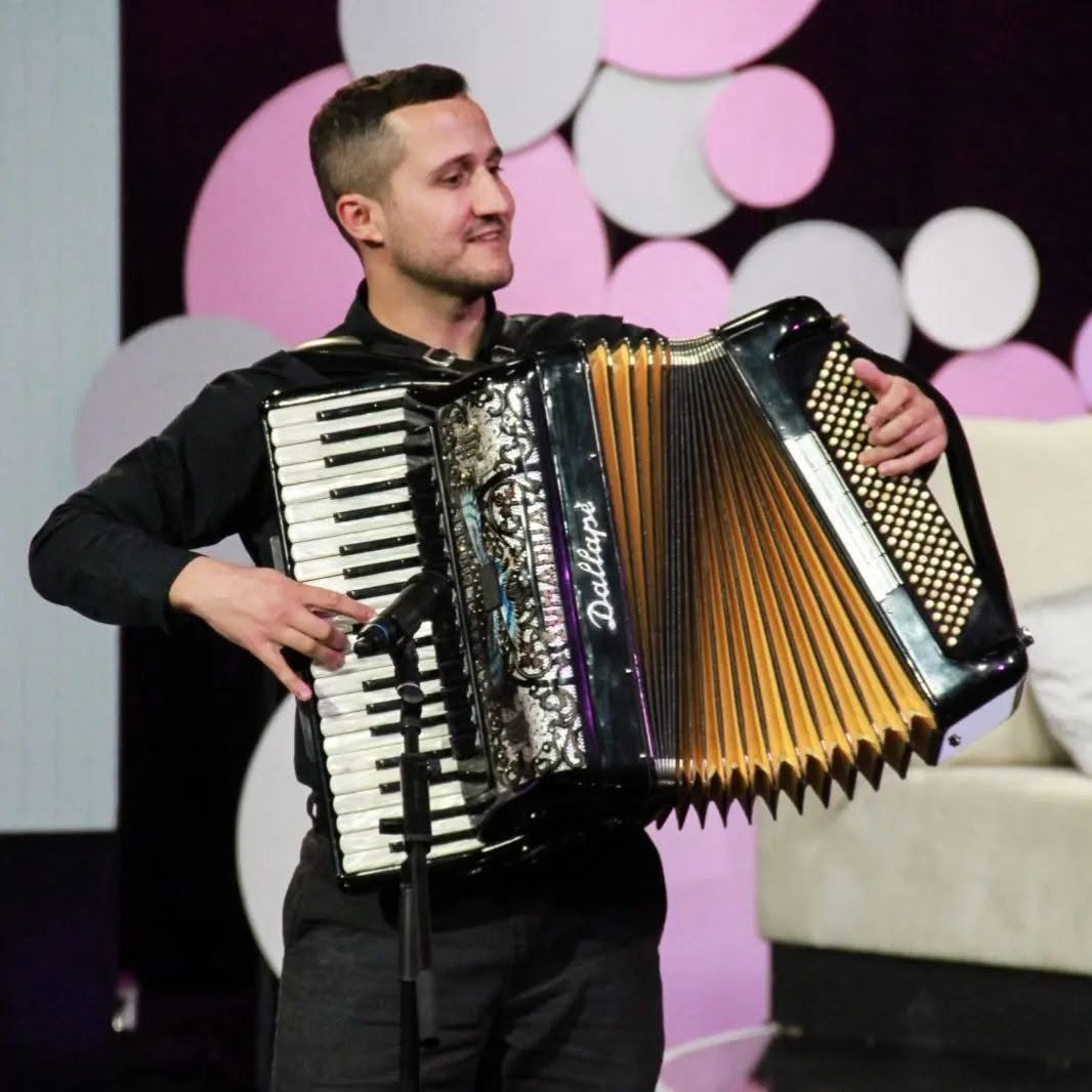 Петар Величкович играет на аккордеоне на сцене
